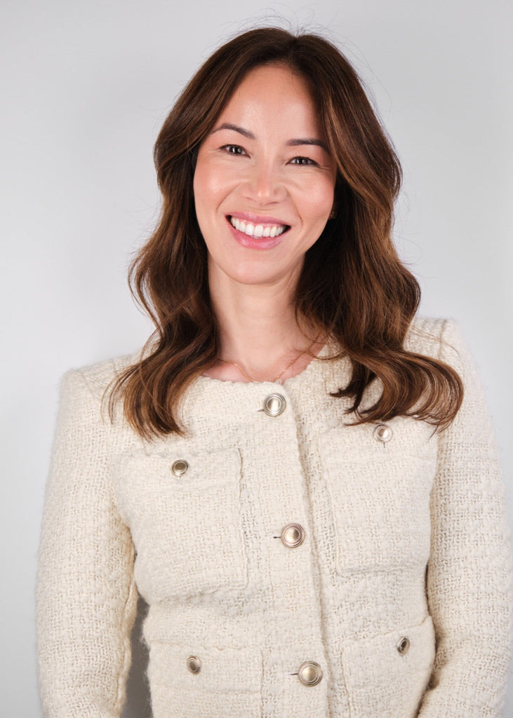 Dr Christine Hall smiling at the camara in a cream button up jacket 